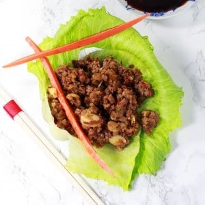 A plate with an Asian Lettuce Wrap with carrots on a table