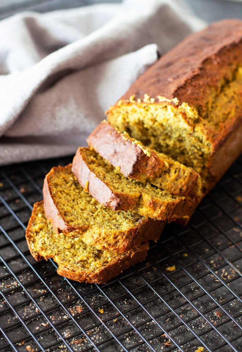 Loaf of Quinoa Banana Bread slices on a cooling rack.