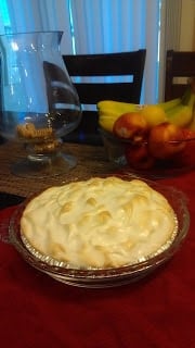 A lemon meringue pie on a wooden table.