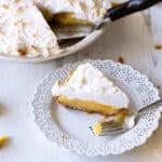 Slice of lemon meringue pie on a plate.