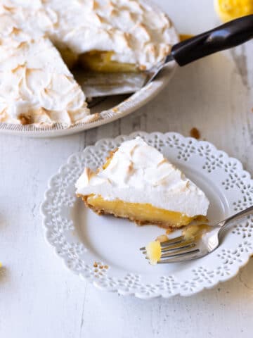 Slice of lemon meringue pie on a plate.
