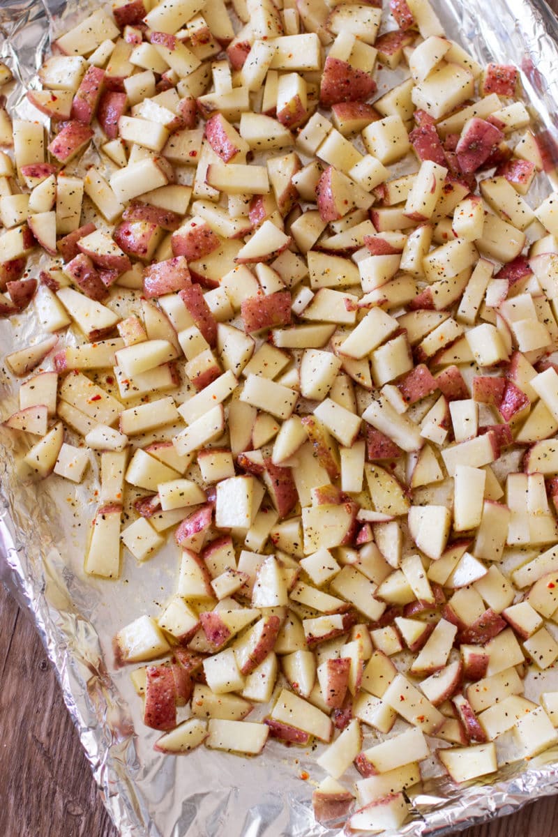 Aluminum foil covered cookie sheet containing marinated red potatoes. 