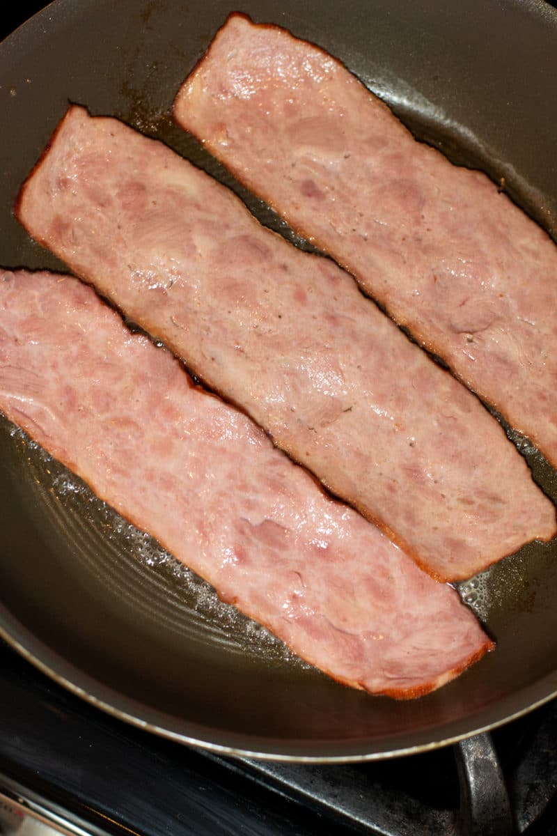 Pan frying bacon in a skillet. 