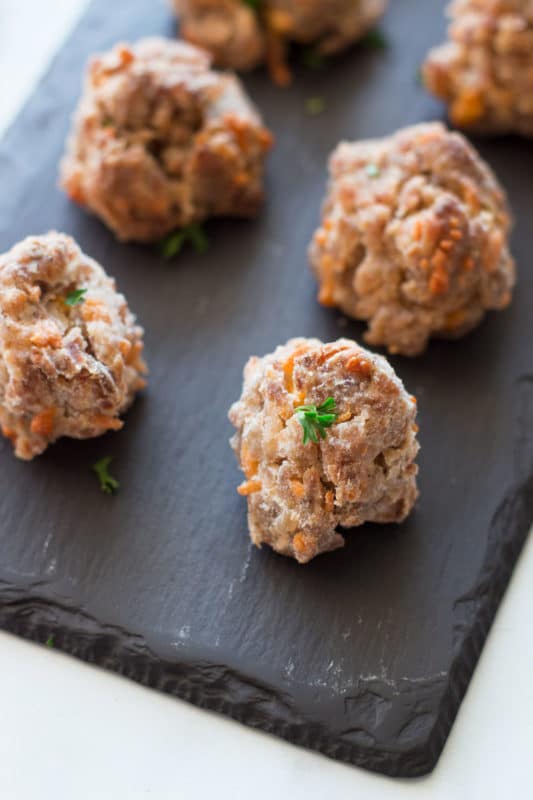 Close up of a cooked sausage ball on a black serving plate.