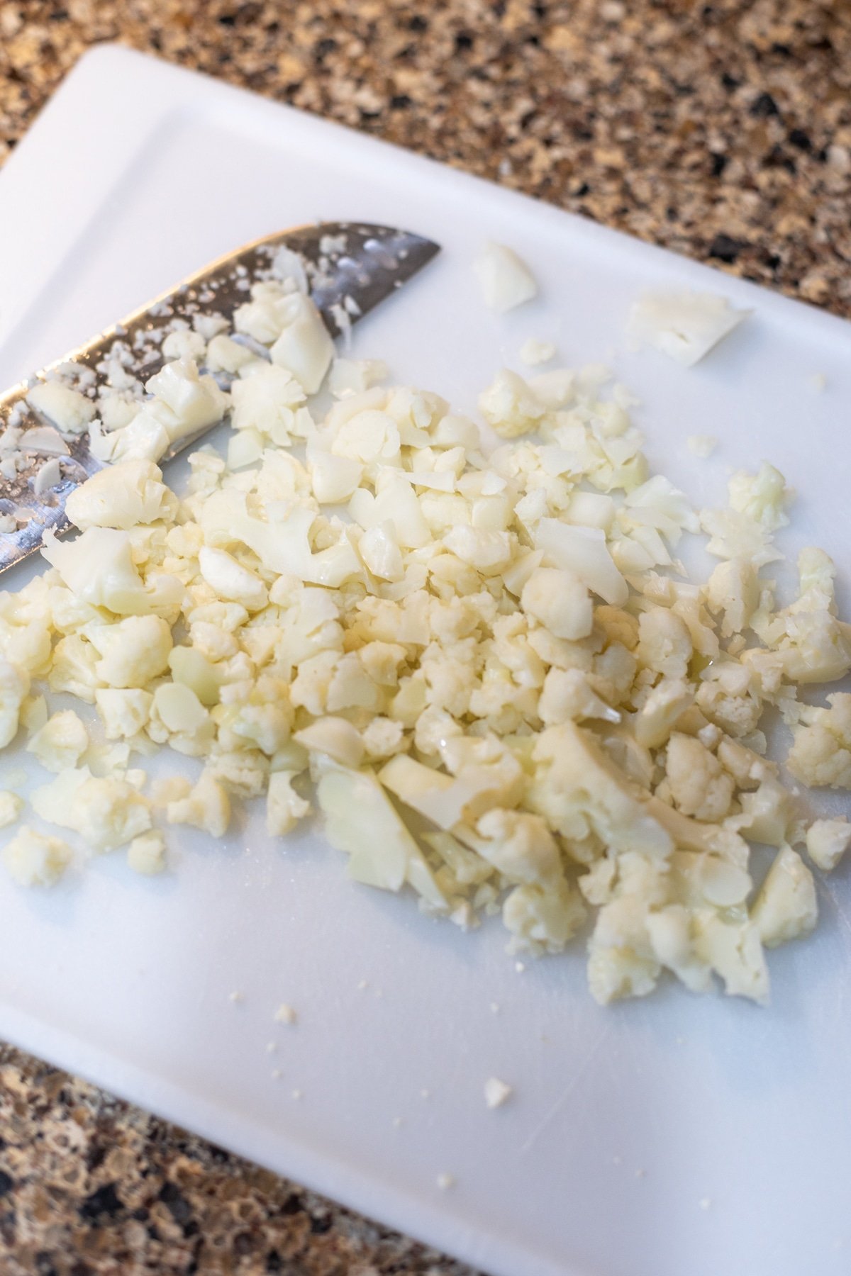 Chopped cauliflower on a cutting board.