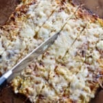 Person slicing breadsticks made from cauliflower.
