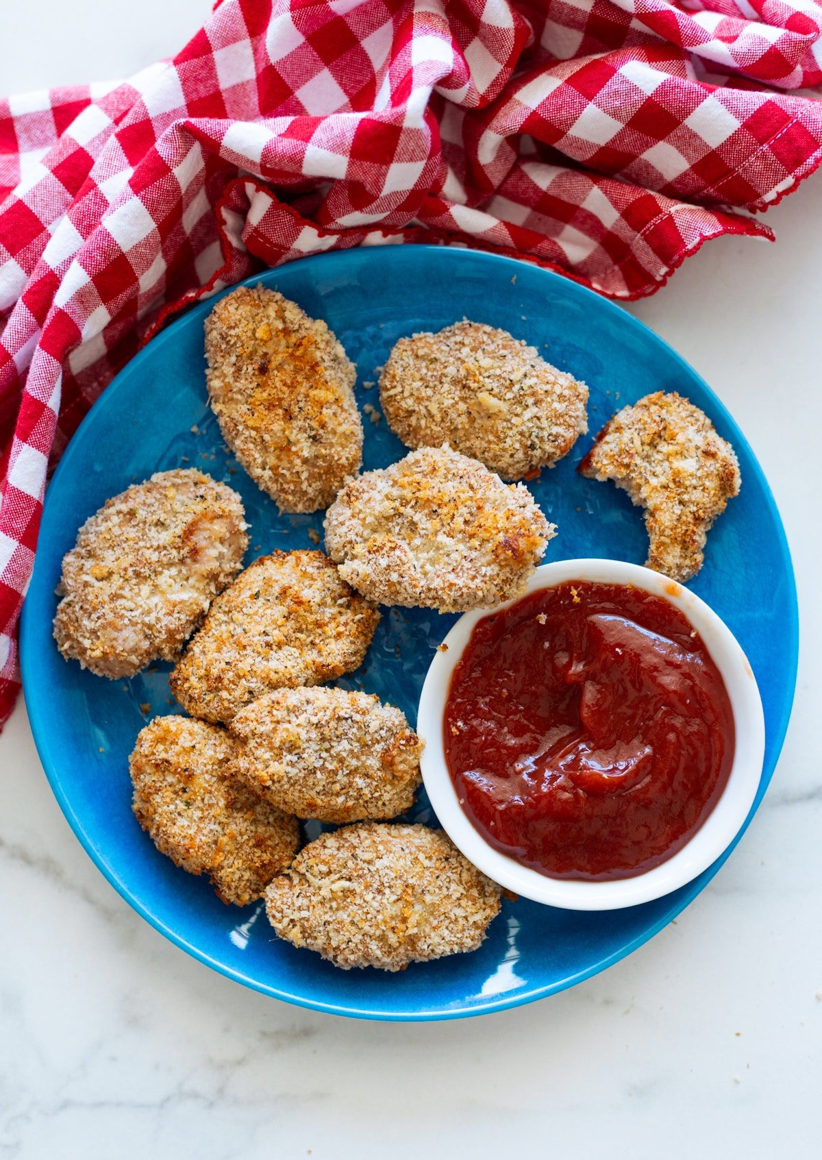 9 baked turkey tots on a plate being dipped in ketchup. 