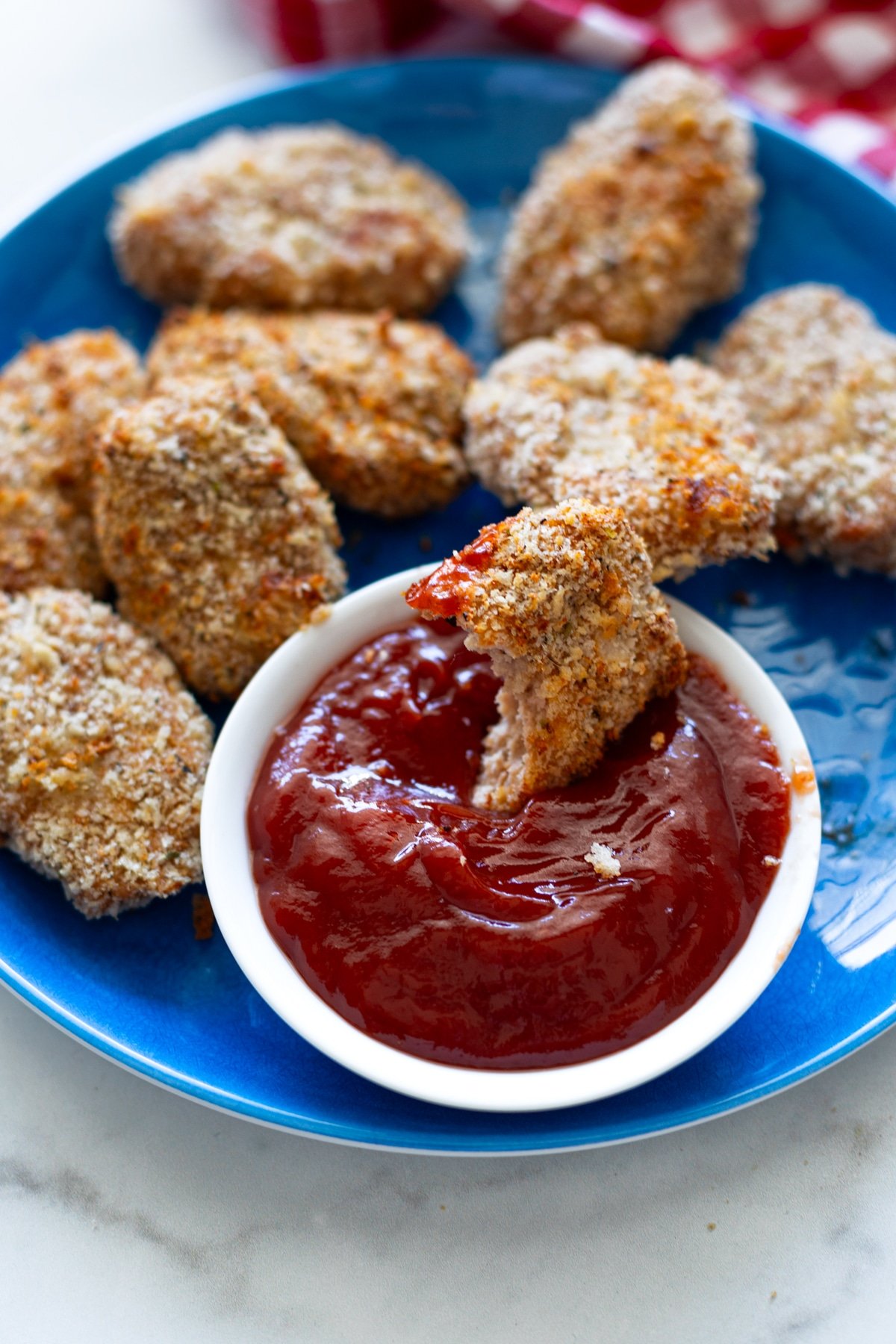 Half eaten turkey tot being dipped into ketchup. 