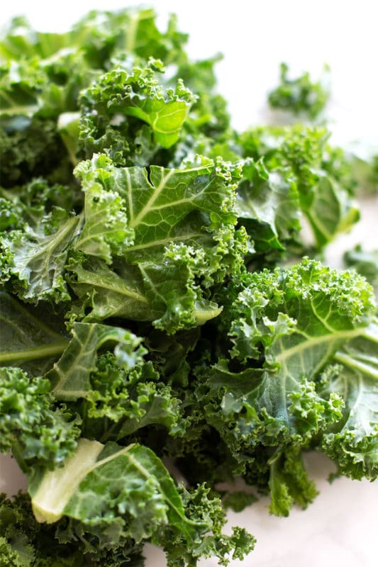 Fresh chopped kale sitting on a white counter.