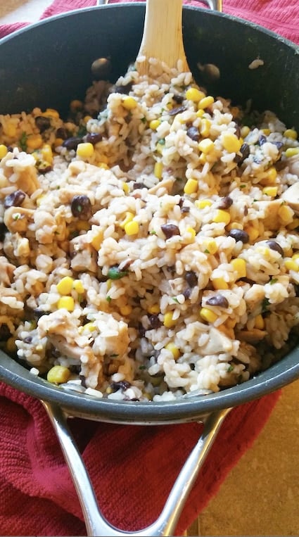 A bowl of rice, beans, corn, and chopped chicken stirred together.