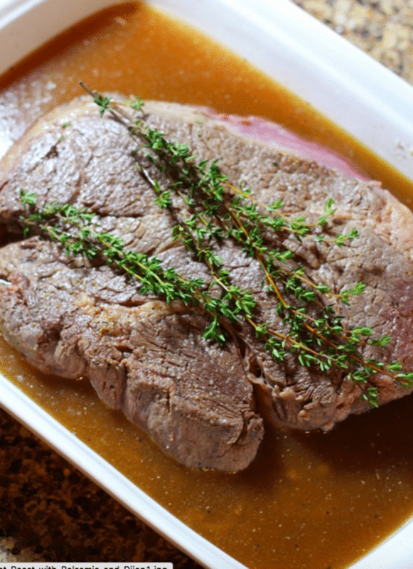 Pan seared chuck roast sitting on top of beef broth and onions.