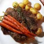 Pot roast being served with potatoes and carrots.