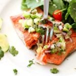 Pan Seared Salmon topped with a cucumber lime salsa, fork in salmon.
