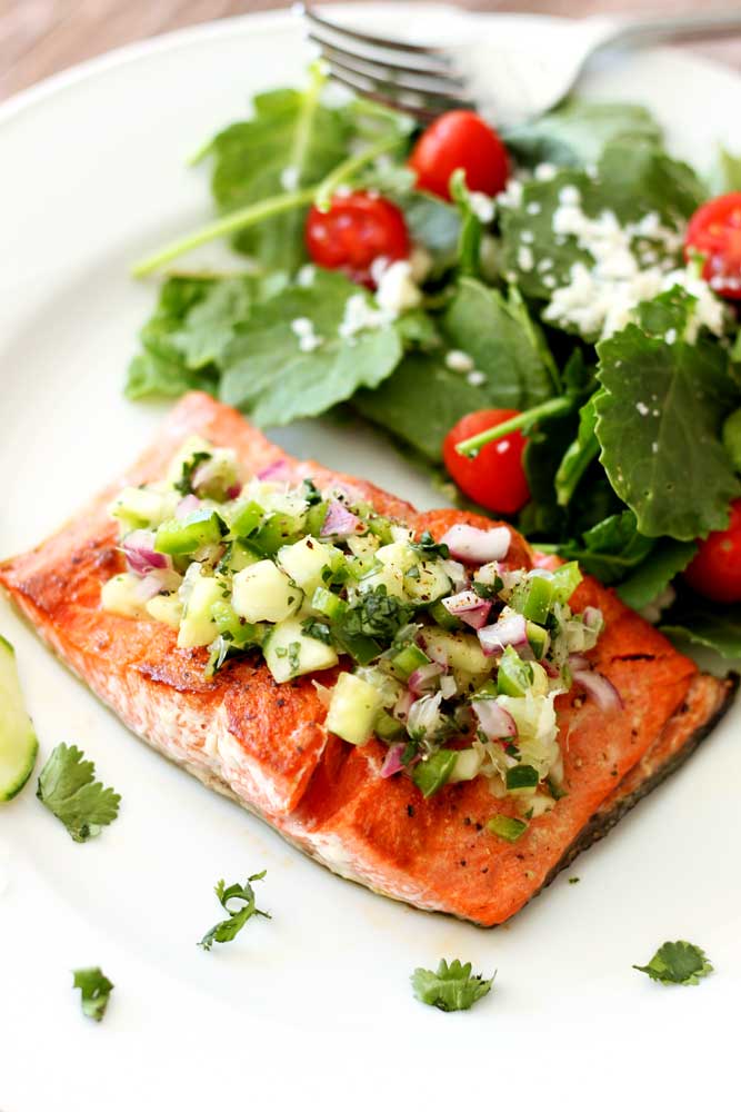 Filet of Pan-Seared Salmon topped with cucumber lime salsa, salad on side.