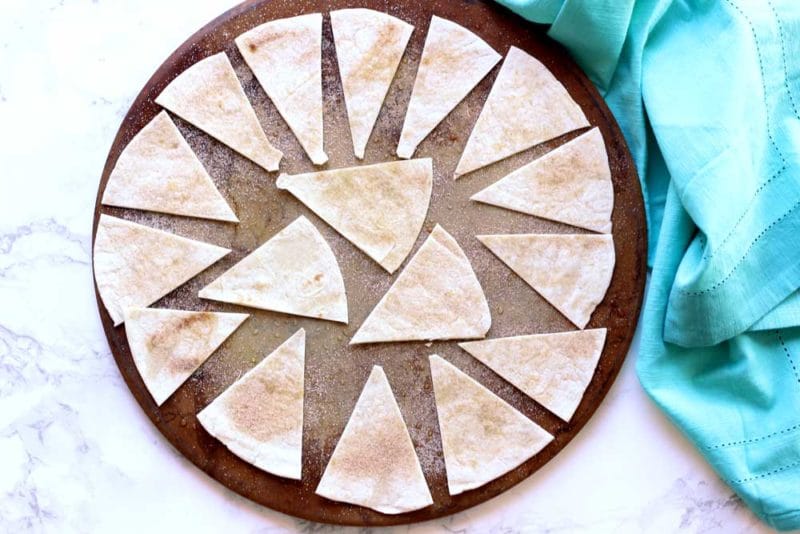 A round cooking stone of triangle cut tortillas sprinkled with cinnamon 