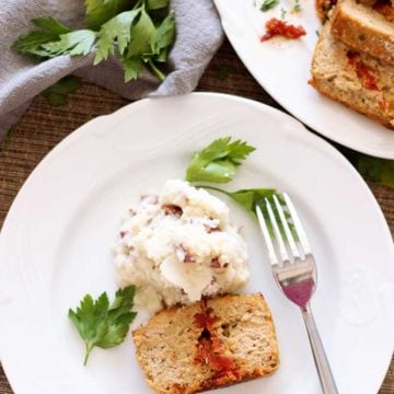 White plate containing Feta and Sun-Dried Tomato Meatloaf with mashed potatoes.