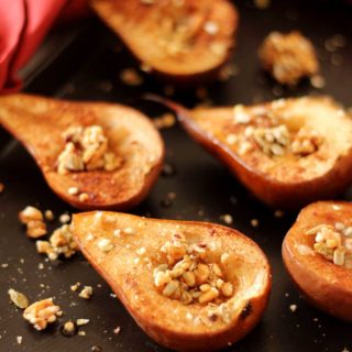 Brown flexipan containing 6 baked pears topped with granola, red napkin around pan.