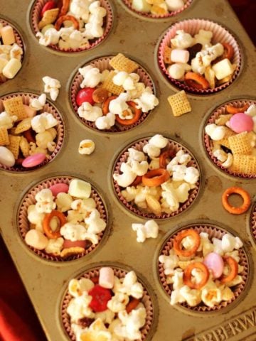 Muffin tin filled with 12 muffin cups of popcorn, chex, pretzels, marshmallows and M&Ms!