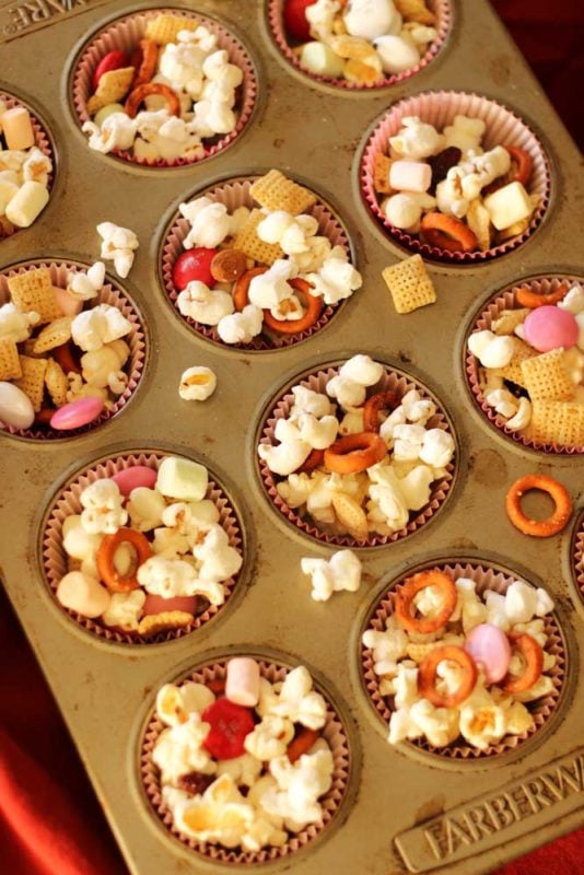 Muffin tin filled with 12 muffin cups of popcorn, chex, pretzels, marshmallows and M&Ms!