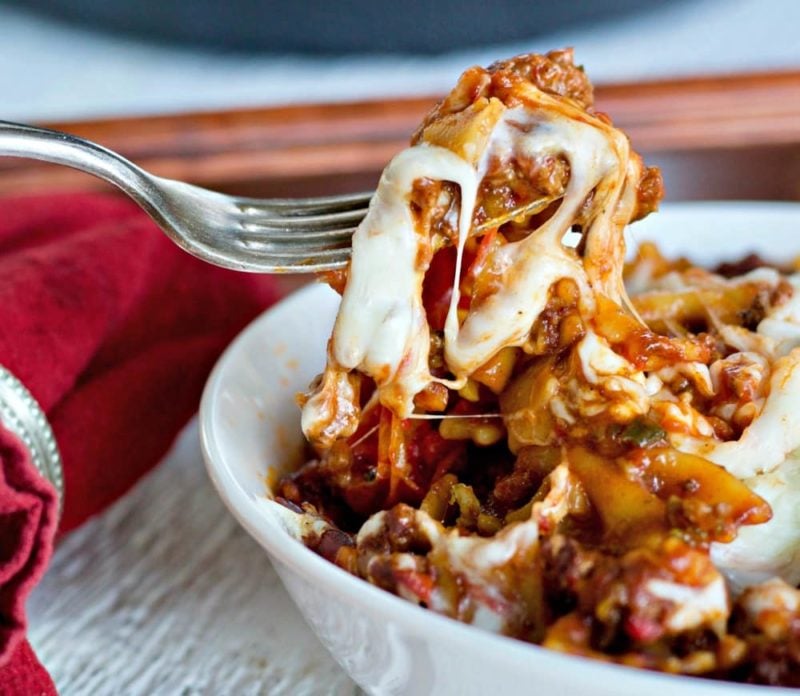 White bowl containing marinara sauce with beef and mozzarella cheese, fork and red napkin. Instant Pot recipe.