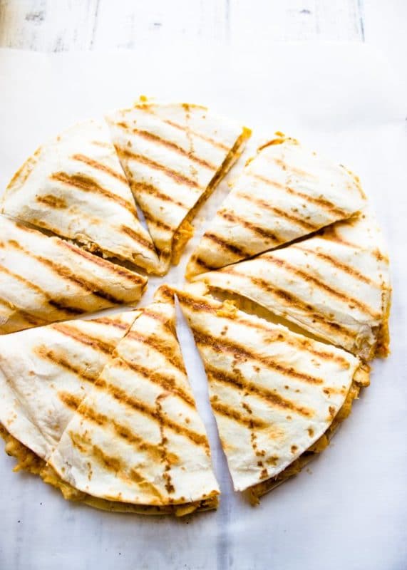 8 slices of chicken quesadilla sitting on a white table.