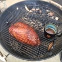 Easy Double Smoked Turkey on a grill with BBQ sauce.