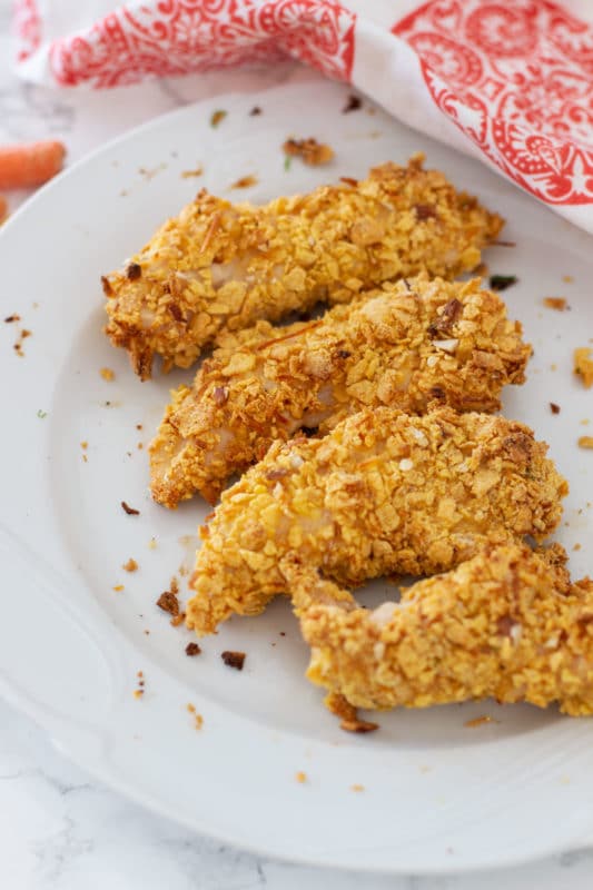 4 oven baked chicken tenders on a white plate.