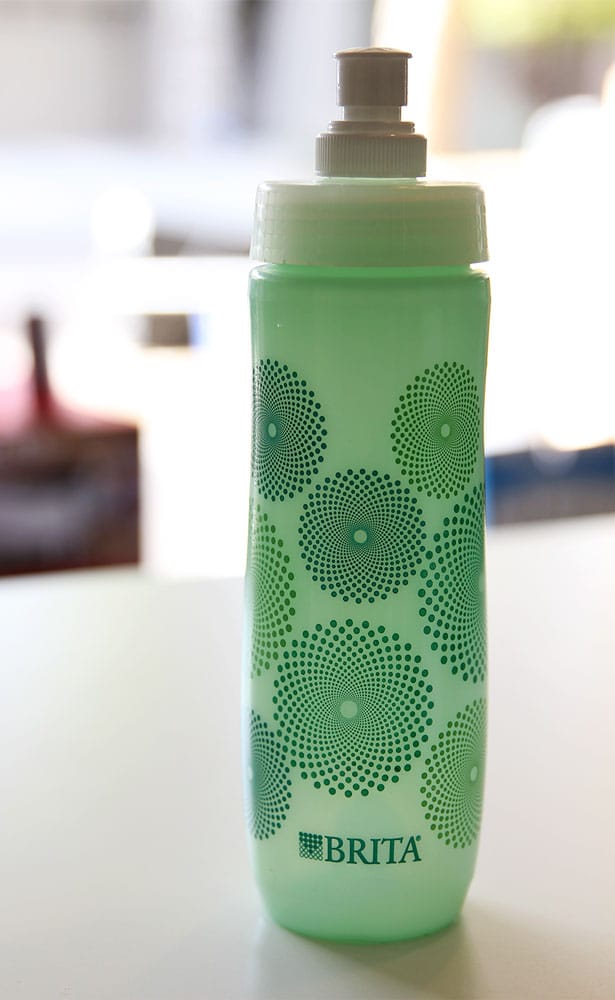 Green water bottle with built in filter featured in a gift guide for travelers.
