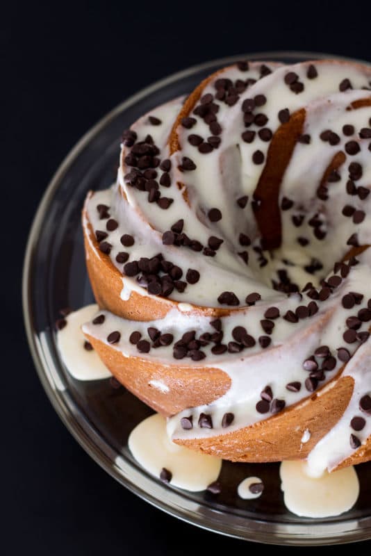 Orange Vanilla Bundt Cake topped with cream cheese frostings and chocolate chips.