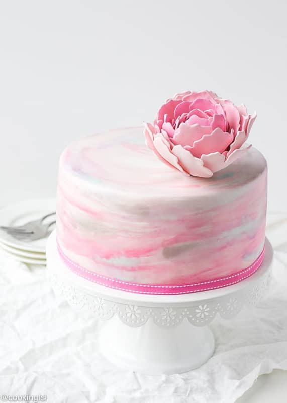 Pink, white and gray fondant cake topped with a pink fondant flower. 