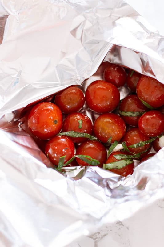 Foil packet containing fresh marinated tomatoes. 