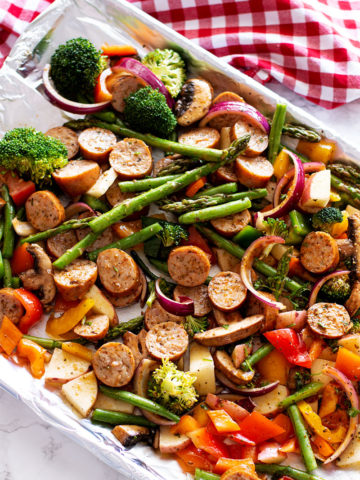 One Pan Smoked Sausage and Vegetables containing broccoli, asparagus, peppers, mushrooms and onion.