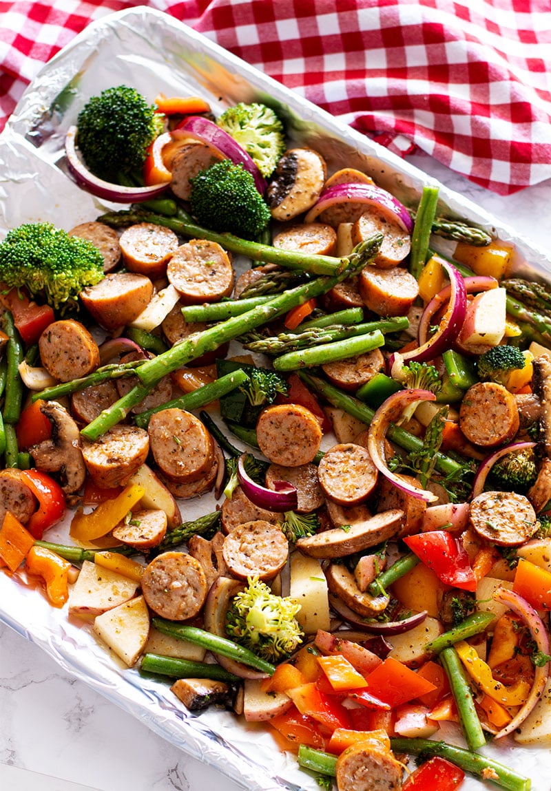 One Pan Smoked Sausage and Vegetables containing broccoli, asparagus, peppers, mushrooms and onion.