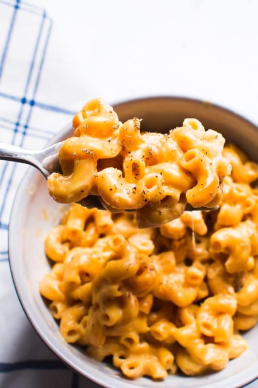 Bowl containing macaroni and cheese, fork in the bowl.