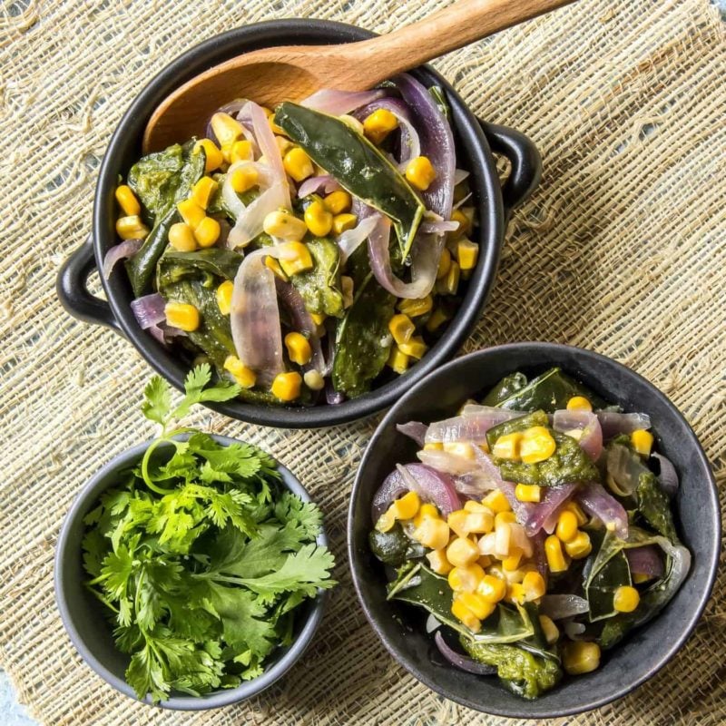 Rajas Con Crema in black bowls containing poblano peppers, onions, and corn finished with a little crème fraîche.