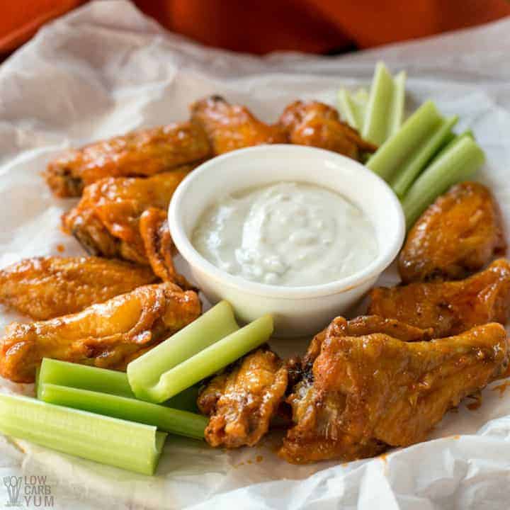 White plate containing 10 Air Fryer Chicken Wings With Buffalo Sauce, side of celery and ranch dressing.