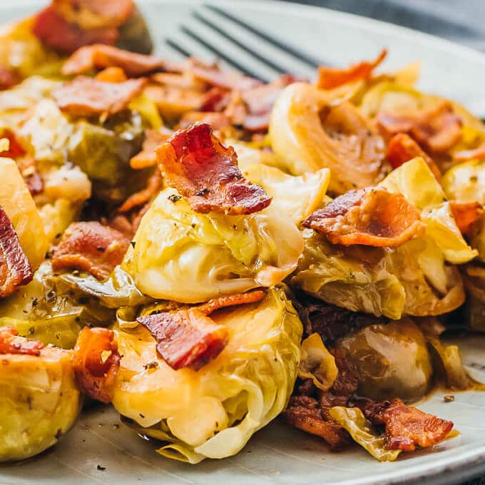 Brussels Sprouts cooked in an instant Pot topped with bacon, fork on side.