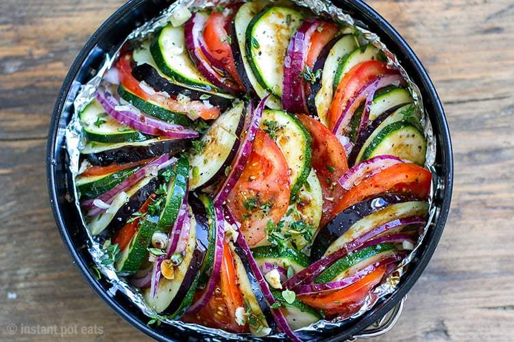 Black Instant Pot Pan containing Ratatouille with tomatoes, zucchini, eggplant, bell peppers, onion, garlic, thyme, basil and marjoram.