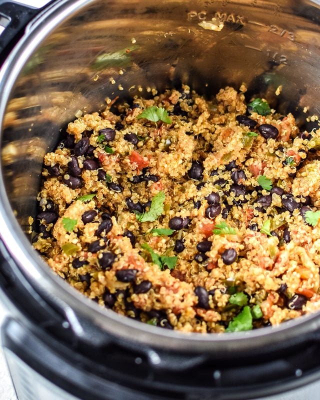 Instant Pot containing Mexican quinoa, black beans and fresh cilantro leaves. 