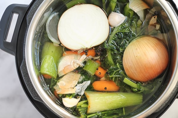 Vegetables, wing bones, garlic and peppercorns in an Instant Pot to make bone broth.