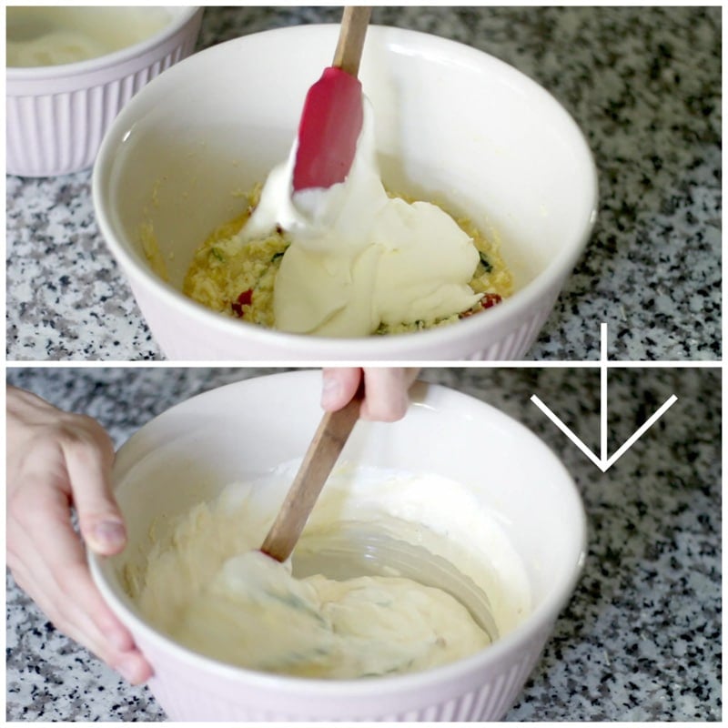 A person adding whipped cream to an egg mixture and stirring it thoroughly in a white bowl with a spatula.