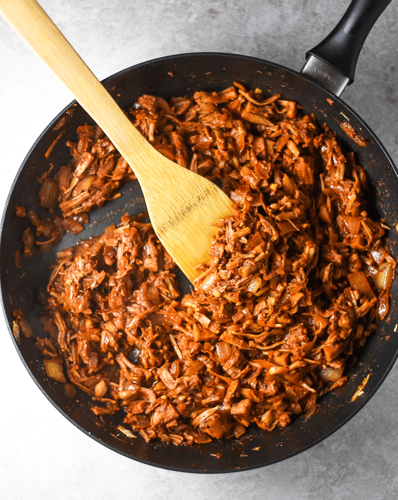 Pan containing jackfruit, salt, smoked paprika, cumin, chili powder, onion powder, cane sugar, chipotle peppers, adobo sauce, soy sauce, water, and lime juice to make jackfruit tacos.