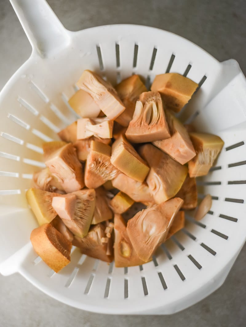 Sliced jackfruit in a white colander. 