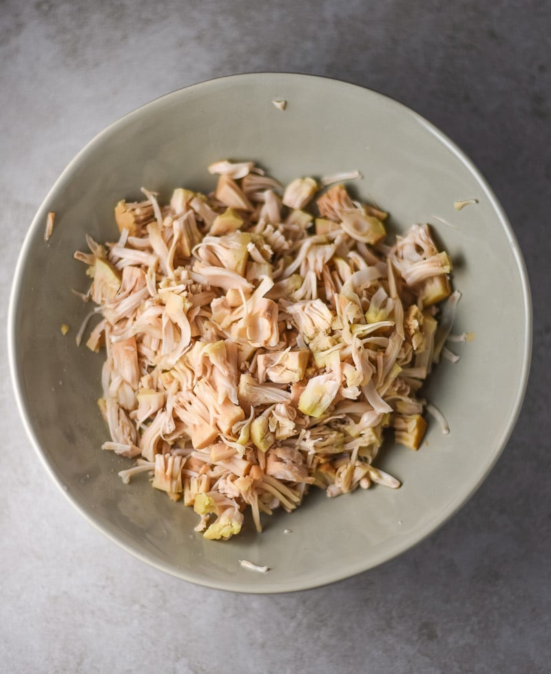 Shredded Jackfruit in a white bowl sitting on a counter.