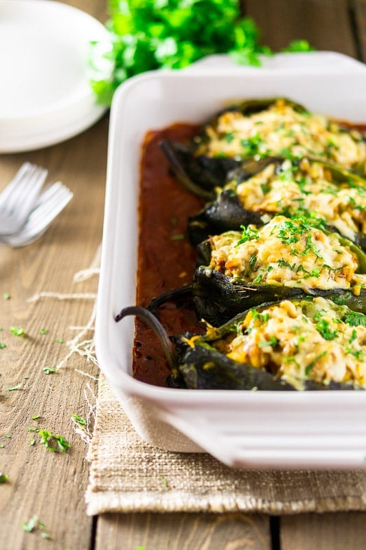 A pan of baked chorizo-butternut squash chile rellenos with ranchero sauce.