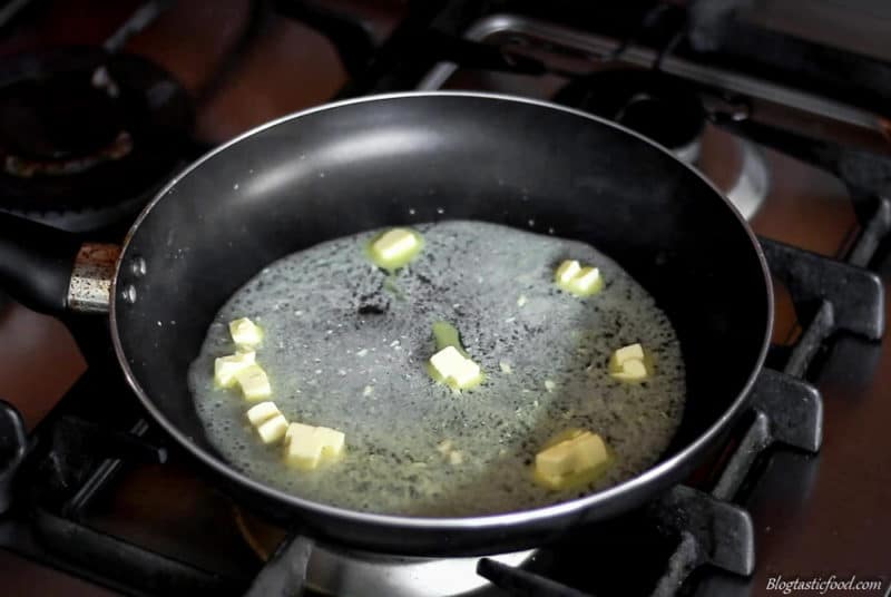 A photo of butter melting into simmering stock.