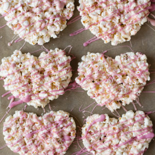 top down view of marshmallow popcorn hearts on a parchment-lined cookie sheet