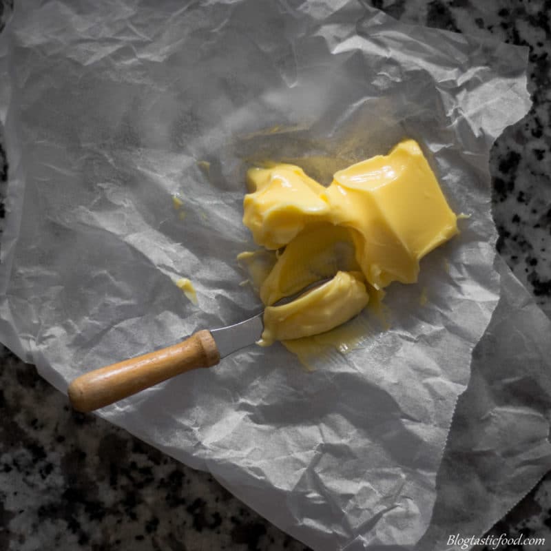 A overhead photo of softened butter on scrunched up baking paper.