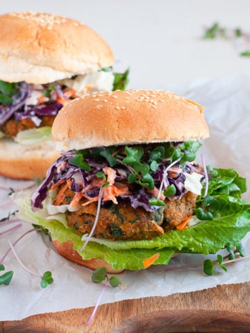 A gluten free and vegan Sweet Potato and Kale Patty on a gluten free bun with a lettuce and slaw topping.