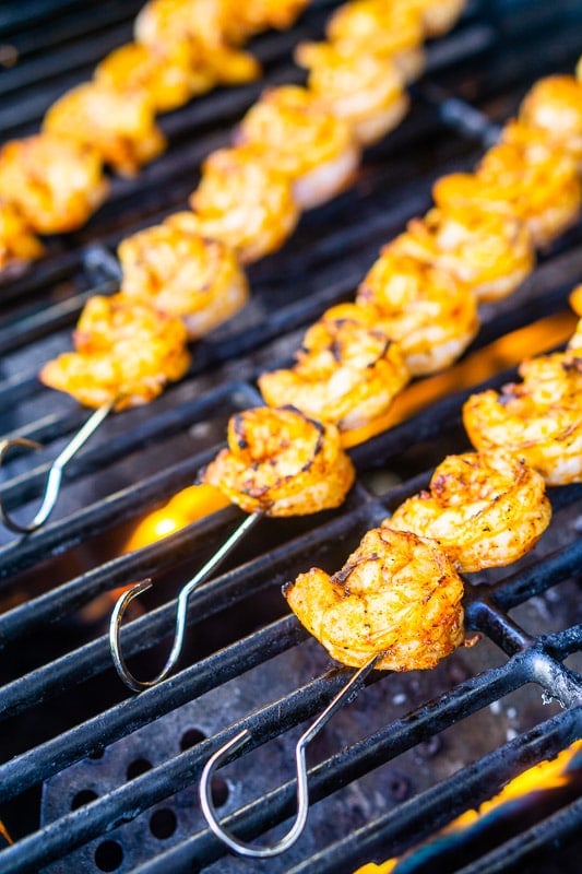 The grilled shrimp skewers cooking on a hot grill.